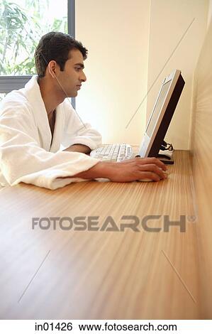 Man in bathrobe, looking at computer View Large Photo Image Stock Photograph - Man in bathrobe, looking at computer. Fotosearch