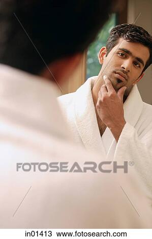 Man in bathrobe looking at himself in mirror View Large Photo Image Stock Image - Man in bathrobe looking at himself in mirror. Fotosearch
