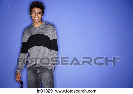 Man standing against blue background, smiling View Large Photo Image Stock Photo - Man standing against blue background, smiling. Fotosearch