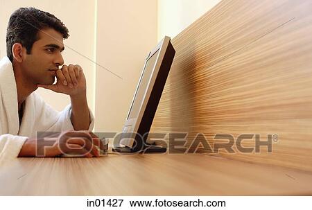 Man using computer at home View Large Photo Image Stock Photo - Man using computer at home. Fotosearch