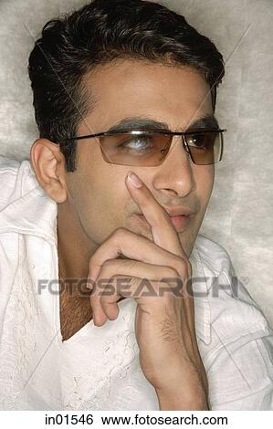 Stock Photograph - Man wearing sunglasses, looking away. Fotosearch