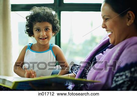 Mother and daughter at home with book, daughter looking at camera View Large Photo Image Stock Image - Mother and daughter at home with book, daughter looking at camera. Fotosearch