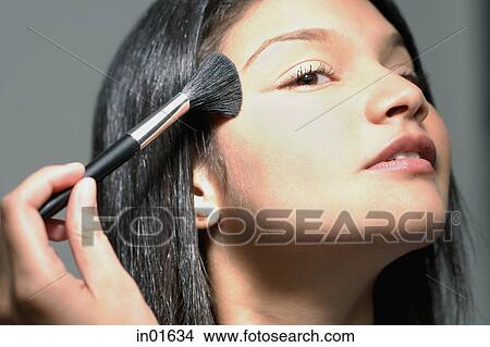 Picture - Woman applying make-up with make up brush. Fotosearch
