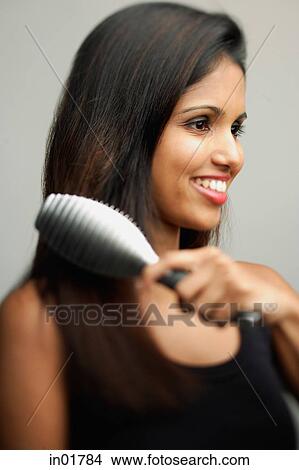 Woman brushing her hair View Large Photo Image Picture - Woman brushing her hair. Fotosearch