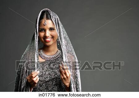 Stock Photograph - Woman in gray sari smiling at camera, portrait. Fotosearch