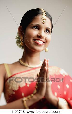 Stock Photo - Woman in sari, hands together. Fotosearch