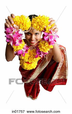 Woman in sari, holding flower garland up towards camera View Large Photo Image Stock Photo - Woman in sari, holding flower garland up towards camera. Fotosearch
