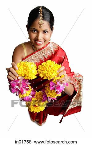 Woman in sari, holding flower garland, smiling View Large Photo Image Stock Photo - Woman in sari, holding flower garland, smiling. Fotosearch