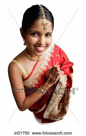 Woman in sari, standing with hands together, smiling up at camera View Large Photo Image Stock Photography - Woman in sari, standing with hands together, smiling up at camera. Fotosearch
