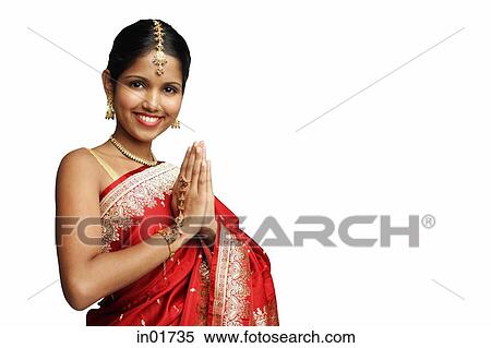 Stock Photography - Woman in traditional Indian costume standing against white background, smiling at camera. Fotosearch