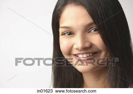 Stock Image - Woman looking at camera, smiling, head shot. Fotosearch