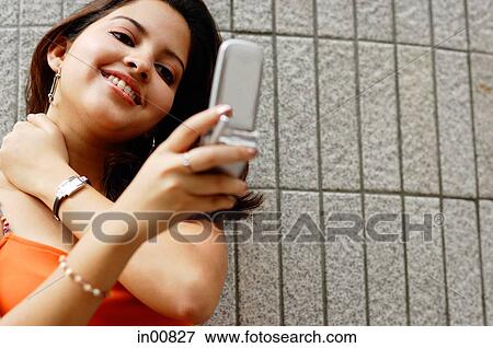 Woman looking at mobile phone, smiling View Large Photo Image Stock Photo - Woman looking at mobile phone, smiling. Fotosearch