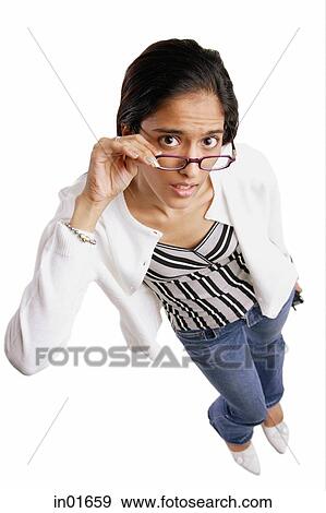 Stock Photo - Woman looking up at camera, adjusting glasses, high angle view. Fotosearch
