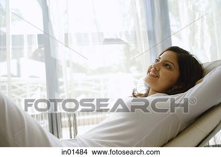Woman lying on chair, looking up View Large Photo Image Picture - Woman lying on chair, looking up. Fotosearch