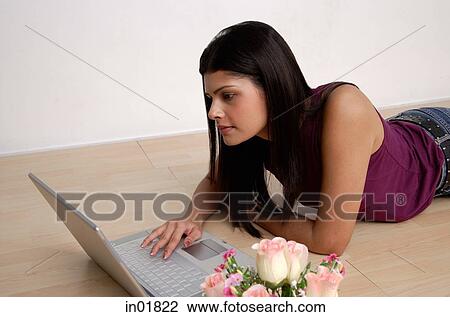 Woman lying on floor, using laptop View Large Photo Image Stock Image - Woman lying on floor, using laptop. Fotosearch