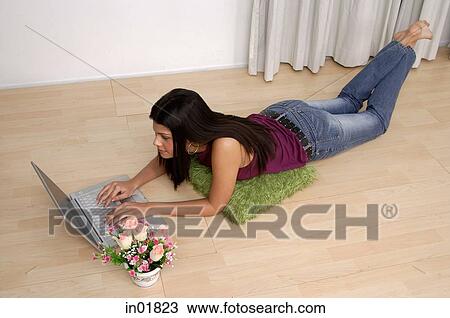 Woman lying on floor, using laptop, high angle view View Large Photo Image Stock Image - Woman lying on floor, using laptop, high angle view. Fotosearch