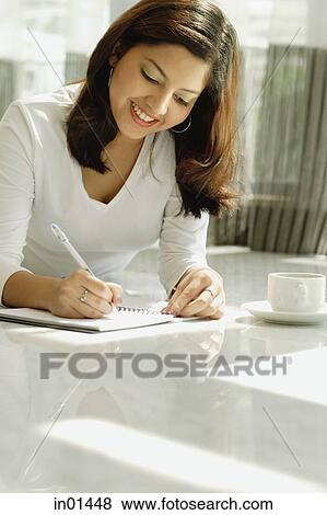 Woman lying on floor, writing in notebook View Large Photo Image Stock Photo - Woman lying on floor, writing in notebook. Fotosearch