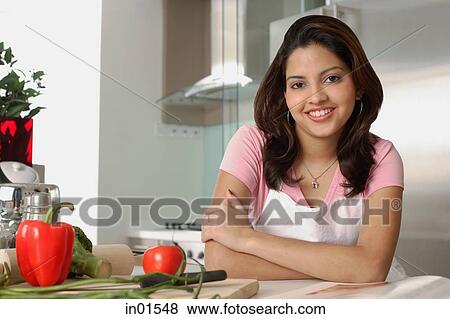 Woman sitting in kitchen, smiling at camera View Large Photo Image Stock Photo - Woman sitting in kitchen, smiling at camera. Fotosearch