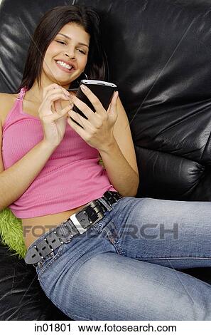 Woman sitting on armchair using PDA, high angle view View Large Photo Image Stock Image - Woman sitting on armchair using PDA, high angle view. Fotosearch