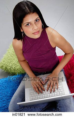 Woman sitting on floor, using laptop, looking up at camera View Large Photo Image Stock Image - Woman sitting on floor, using laptop, looking up at camera. Fotosearch