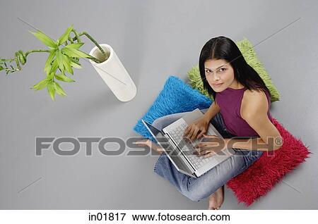Woman sitting on floor with laptop, looking up at camera View Large Photo Image Stock Photo - Woman sitting on floor with laptop, looking up at camera. Fotosearch