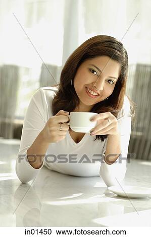 Woman smiling at camera, holding cup View Large Photo Image Stock Image - Woman smiling at camera, holding cup. Fotosearch