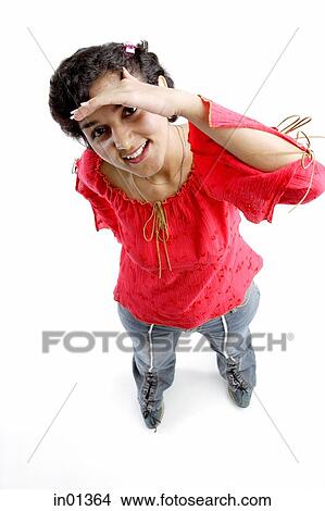Woman smiling at camera, shielding eyes View Large Photo Image Picture - Woman smiling at camera, shielding eyes. Fotosearch