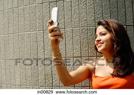 Stock Photo - Woman taking a photo using mobile phone. Fotosearch
