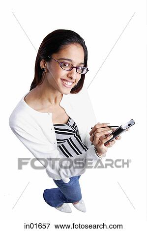 Stock Photo - Woman using PDA, smiling, high angle view. Fotosearch