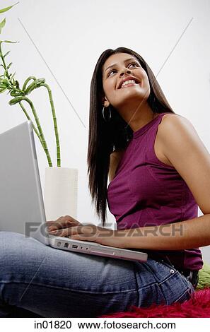 Woman with laptop, smiling, looking away View Large Photo Image Stock Image - Woman with laptop, smiling, looking away. Fotosearch