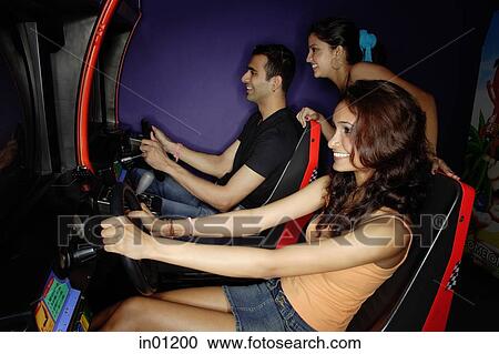 Young adults in a video game arcade, playing games View Large Photo Image Stock Image - Young adults in a video game arcade, playing games. Fotosearch