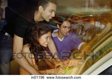 Young adults in amusement arcade, playing games View Large Photo Image Stock Photograph - Young adults in amusement arcade, playing games. Fotosearch
