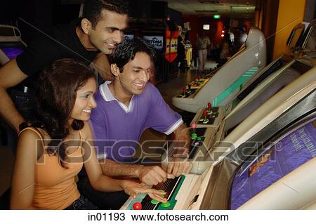 Young adults in video arcade View Large Photo Image Stock Image - Young adults in video arcade. Fotosearch