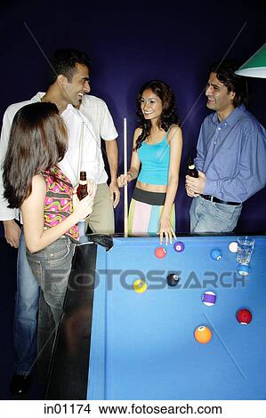 Young adults standing around pool table View Large Photo Image Picture - Young adults standing around pool table. Fotosearch