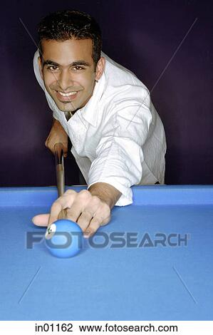 Young man playing pool, smiling at camera, portrait View Large Photo Image Stock Image - Young man playing pool, smiling at camera, portrait. Fotosearch