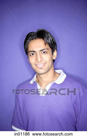 Young man wearing purple shirt standing against purple wall View Large Photo Image Stock Photograph - Young man wearing purple shirt standing against purple wall. Fotosearch