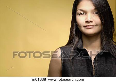 Stock Photo - Young woman against yellow background. Fotosearch