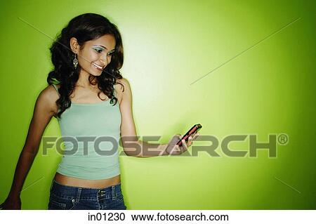 Young woman in green tank top, looking at mobile phone View Large Photo Image Stock Image - Young woman in green tank top, looking at mobile phone. Fotosearch