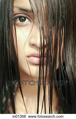 Young woman looking at camera through long wet hair View Large Photo Image Stock Photograph - Young woman looking at camera through long wet hair. Fotosearch