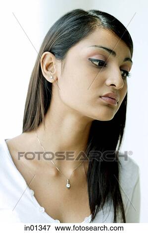 Stock Photo - Young woman with long hair, looking away. Fotosearch