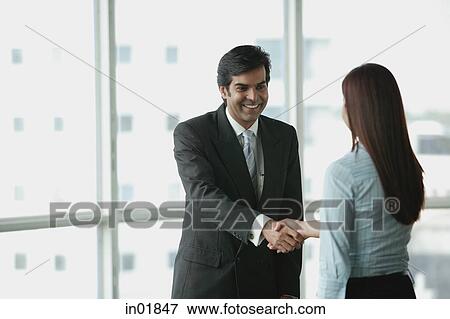 Stock Photo - Businessman and businesswoman shaking hands. Fotosearch