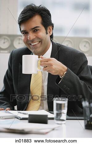 Businessman in office holding mug, smiling View Large Photo Image Stock Image - Businessman in office holding mug, smiling. Fotosearch