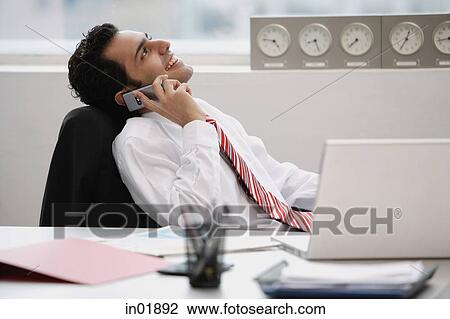 Businessman in office, using mobile phone View Large Photo Image Stock Image - Businessman in office, using mobile phone. Fotosearch