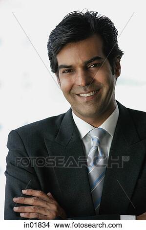 Businessman smiling at camera, arms crossed View Large Photo Image Picture - Businessman smiling at camera, arms crossed. Fotosearch