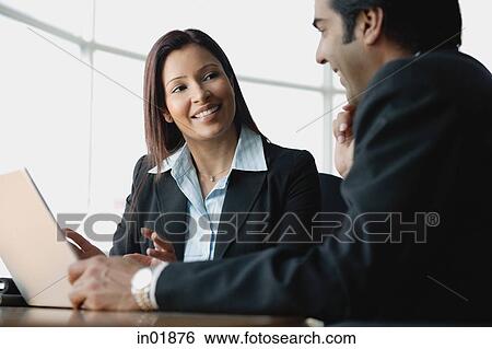 Businesswoman and businessman using laptop View Large Photo Image Stock Photograph - Businesswoman and businessman using laptop. Fotosearch