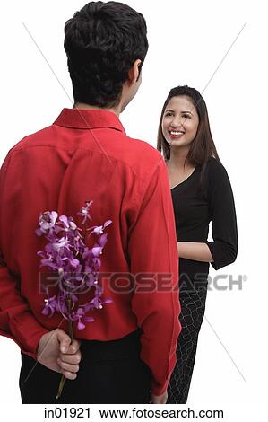 Man holding flowers behind his back, facing woman View Large Photo Image Stock Image - Man holding flowers behind his back, facing woman. Fotosearch