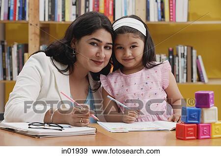 Stock Photo - Woman and girl with books, looking at camera. Fotosearch