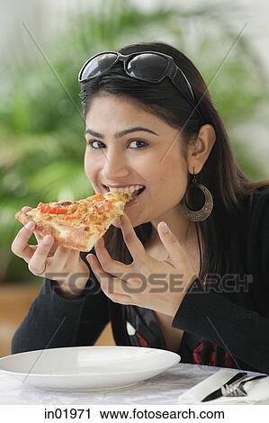 Woman eating a slice of pizza View Large Photo Image Stock Image - Woman eating a slice of pizza. Fotosearch