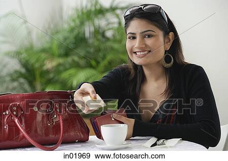Woman in cafe, holding credit card toward camera View Large Photo Image Stock Photo - Woman in cafe, holding credit card toward camera. Fotosearch