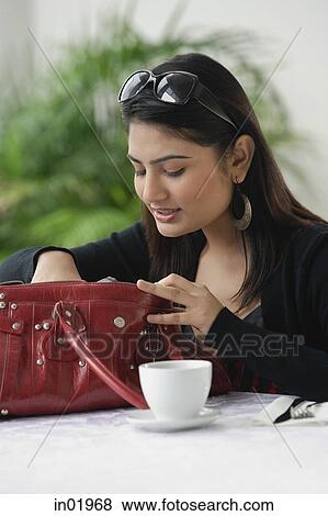 Woman in cafe, looking into her bag View Large Photo Image Stock Photo - Woman in cafe, looking into her bag. Fotosearch
